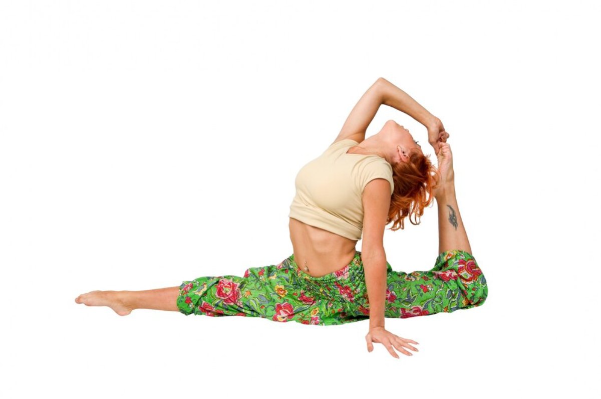 A woman with red hair performs a complex yoga pose, stretching her back and holding one foot while seated in a split position.